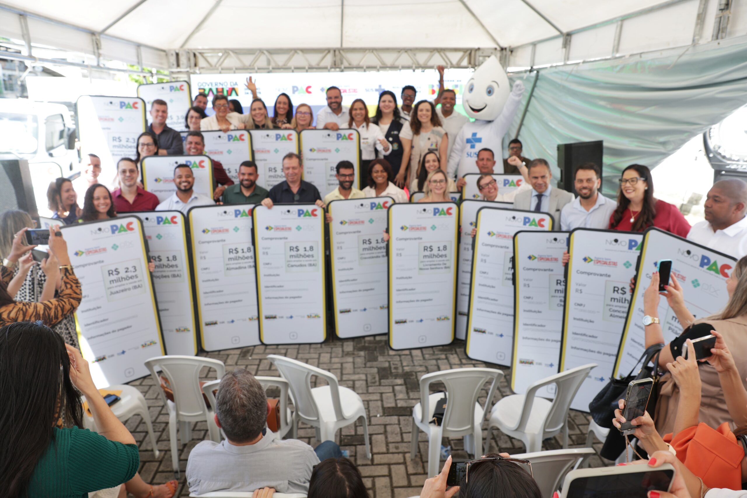 Autoridades e representantes exibem placas de repasse de recursos durante evento do PAC na Bahia para investimentos em saúde