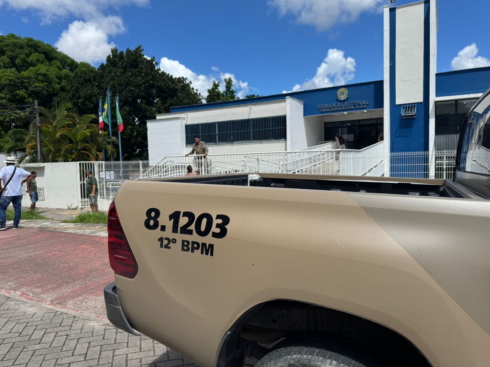 Viatura da Polícia Militar em frente ao Fórum Eleitoral de Camaçari após ocorrência que deixou um homem morto e um vigilante ferido.