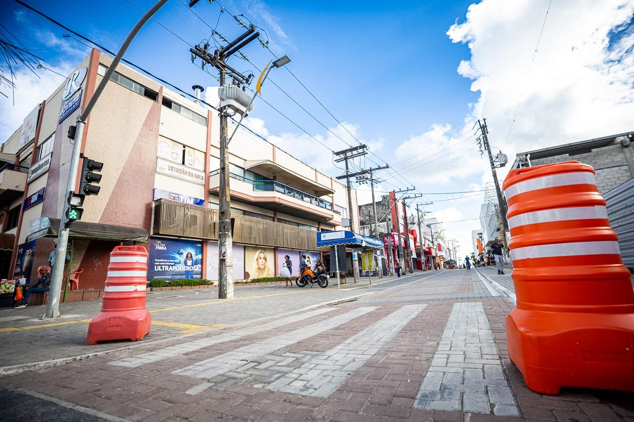 Trânsito no Centro de Camaçari com calçadão na Avenida Getúlio Vargas e estruturas de sinalização para organização de embarque e descarga