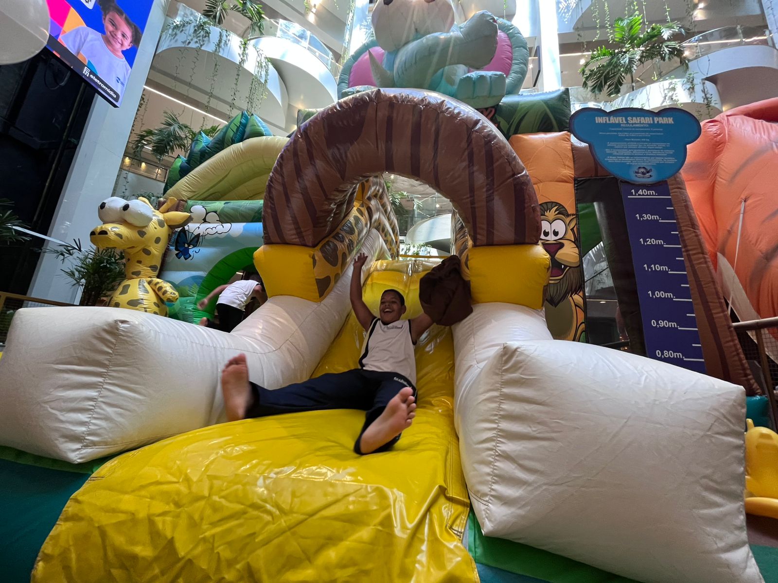 Projeto Árvore dos Sonhos do Shopping Barra no Natal de 2025 com criança brincando em atração inflável