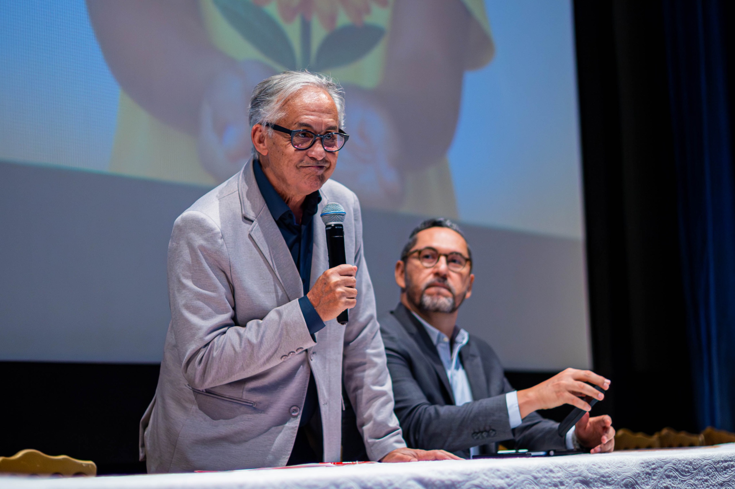Professor doutor Benedito Rodrigues dos Santos fala ao microfone durante seminário em Camaçari.