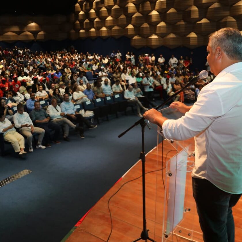 Participantes acompanham evento da agricultura familiar em auditório durante discurso em palco na Bahia.