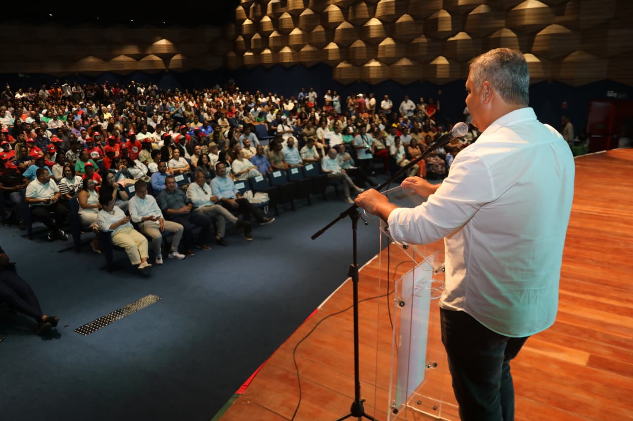 Participantes acompanham evento da agricultura familiar em auditório durante discurso em palco na Bahia.