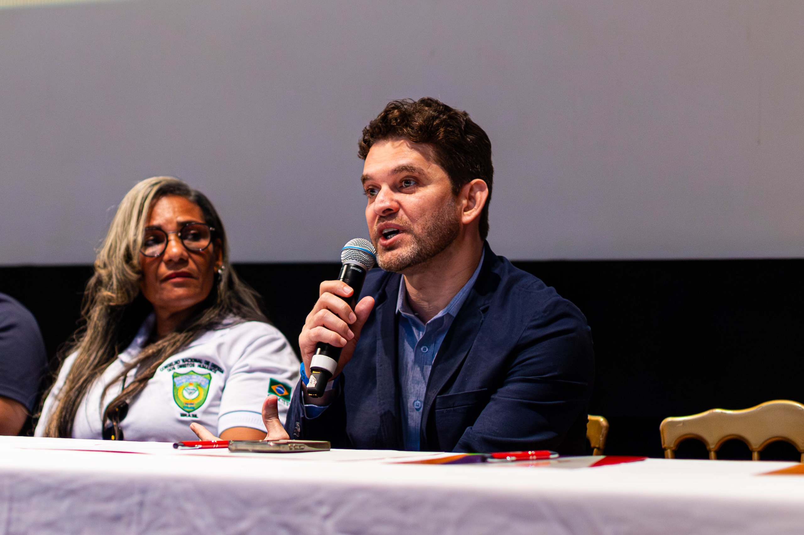 Professor mestre Igor Gomes da Silva, reitor da Universidade Corporativa do Brasil, fala ao microfone durante evento em Camaçari.