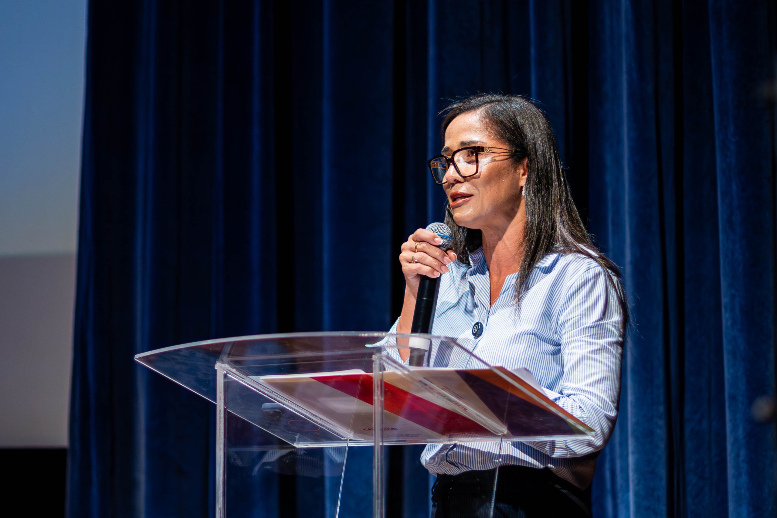 Jeane Gleyde, secretária de Desenvolvimento Social e Cidadania, fala ao microfone durante evento em Camaçari.