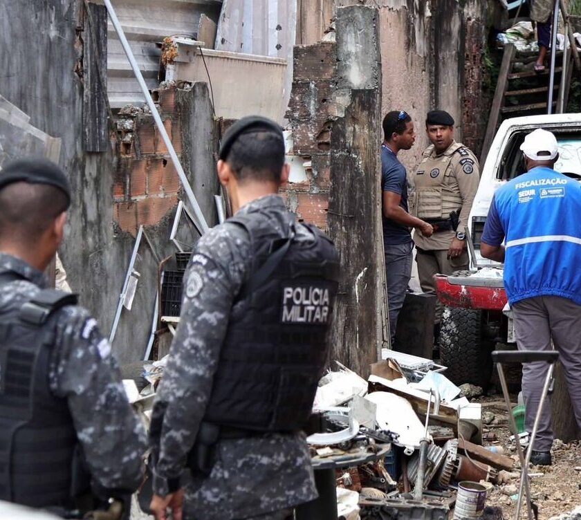 Agentes de fiscalização e policiais atuam em ferro-velho durante a Operação Escudo Urbano em Salvador.