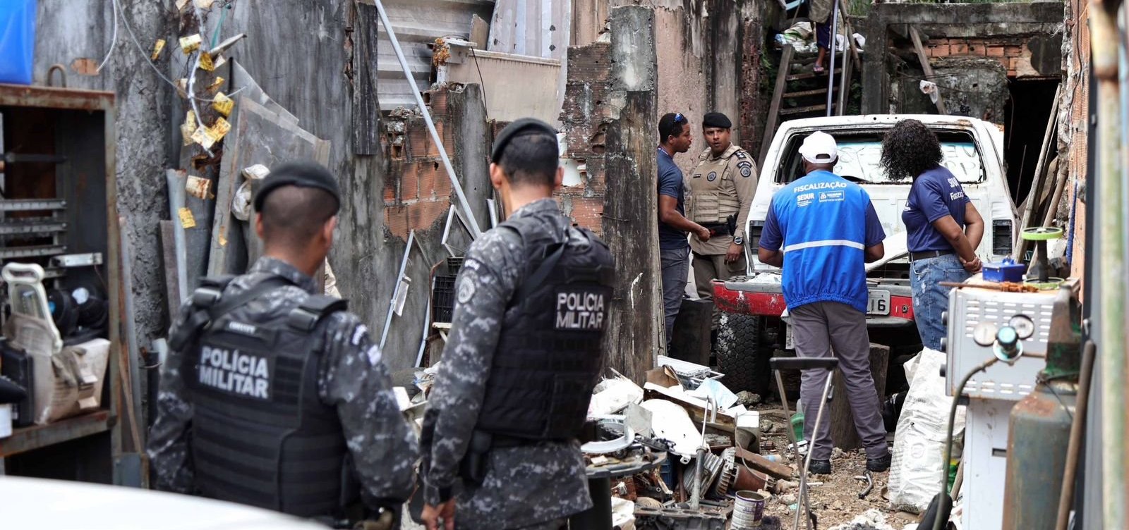 Agentes de fiscalização e policiais atuam em ferro-velho durante a Operação Escudo Urbano em Salvador.