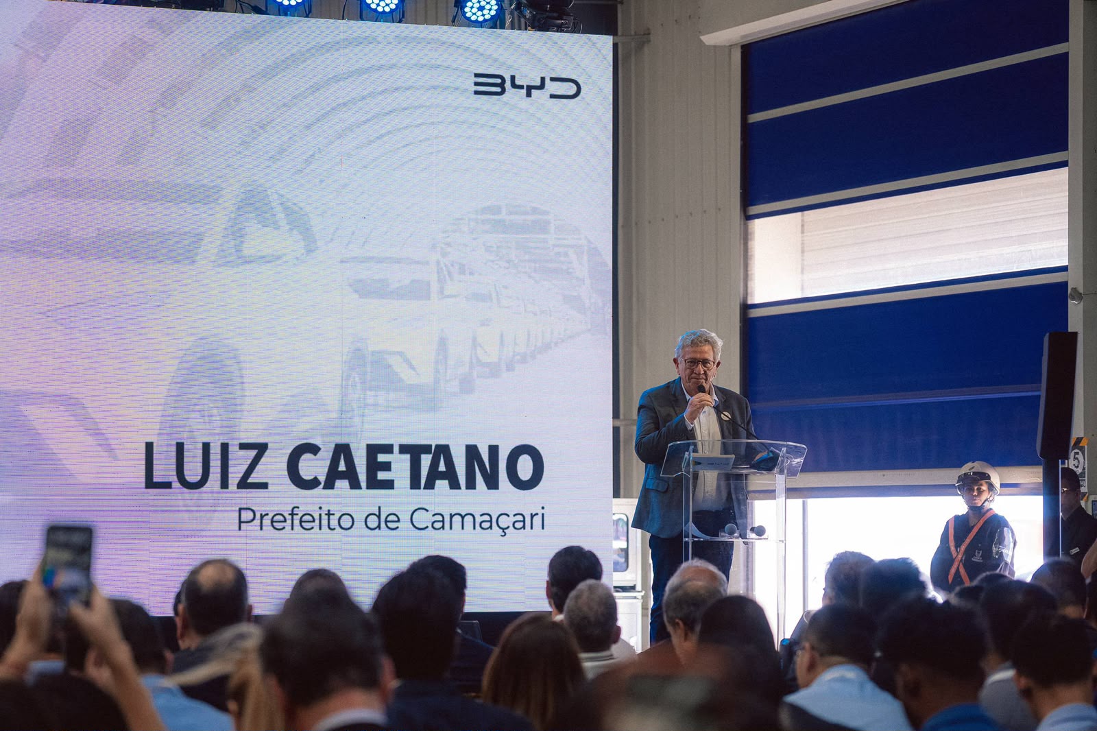 Prefeito Luiz Caetano discursa durante evento que celebra a produção de 100 mil veículos da BYD na fábrica de Camaçari, marco para o desenvolvimento econômico do município.