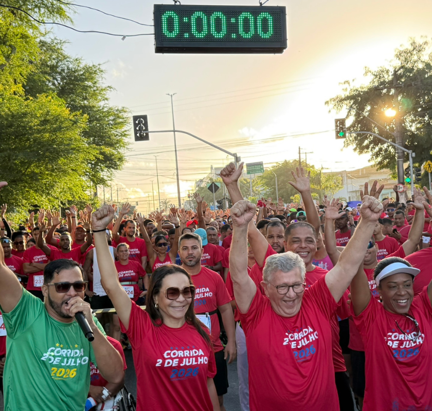 Participantes da Corrida 2 de Julho 2026 celebram a largada do evento em Camaçari, com centenas de corredores reunidos na avenida durante as comemorações da Independência da Bahia.